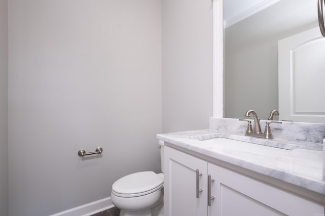 bathroom with vanity, toilet, and ornamental molding