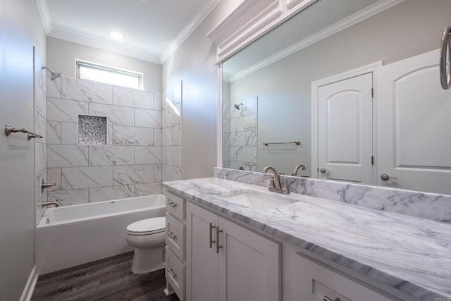 full bathroom featuring vanity, crown molding, hardwood / wood-style floors, toilet, and tiled shower / bath