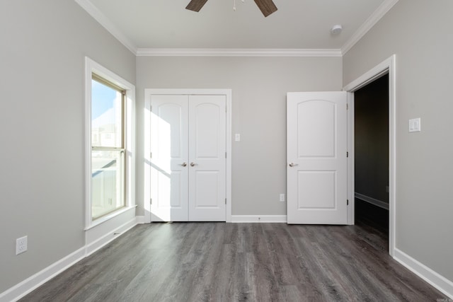 unfurnished bedroom with dark wood-type flooring, a closet, ceiling fan, and crown molding