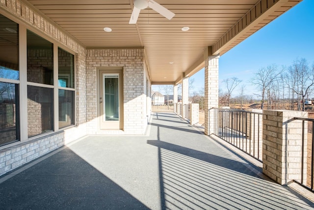 view of patio with ceiling fan and a balcony