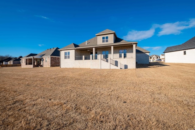 rear view of house featuring a yard