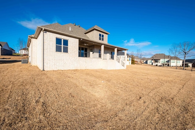 back of property featuring cooling unit and a lawn