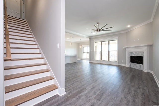 unfurnished living room featuring a fireplace, hardwood / wood-style floors, ceiling fan, and crown molding