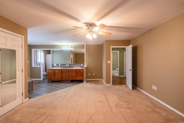 unfurnished bedroom with carpet flooring, ceiling fan, and sink