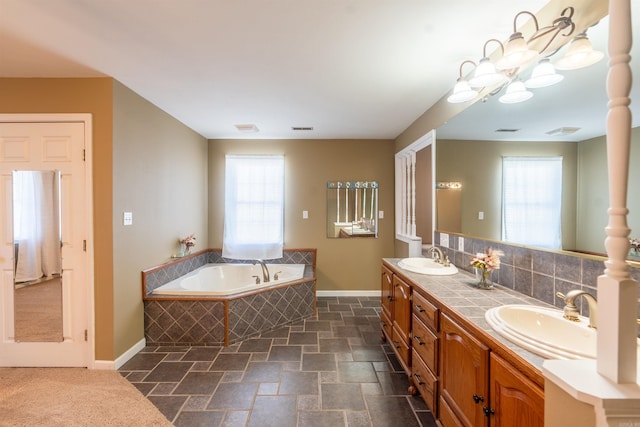 bathroom with vanity, decorative backsplash, tiled bath, and an inviting chandelier