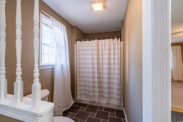 bathroom with shower / bath combo and toilet