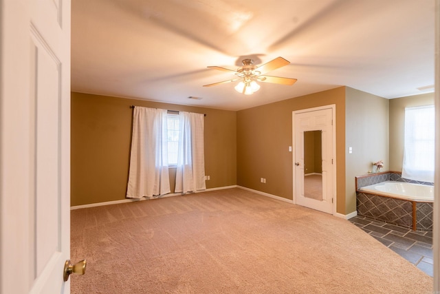 spare room featuring dark carpet and ceiling fan