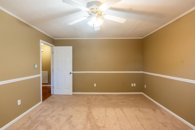 carpeted spare room with ceiling fan and ornamental molding