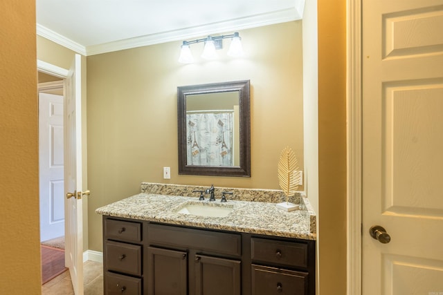 bathroom featuring tile patterned flooring, vanity, and crown molding