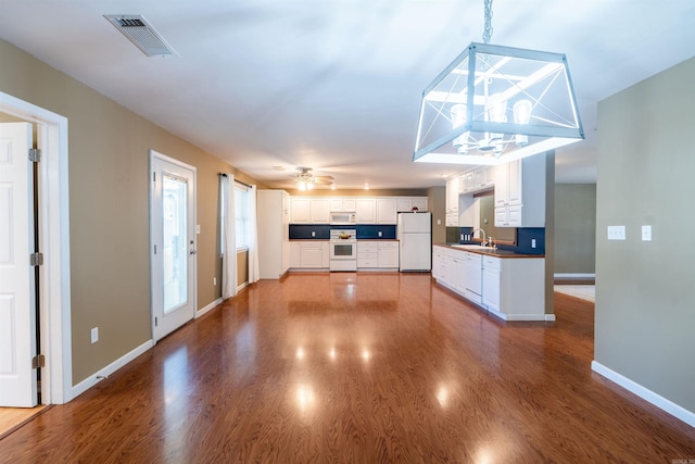 unfurnished living room with ceiling fan, sink, and hardwood / wood-style flooring