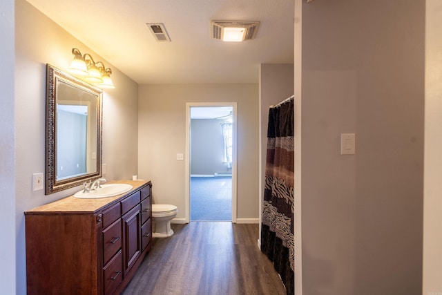 bathroom featuring wood-type flooring, vanity, and toilet