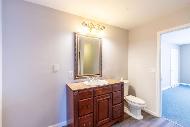 bathroom featuring vanity, toilet, and wood-type flooring