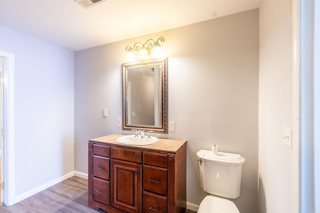 bathroom with vanity, toilet, and wood-type flooring