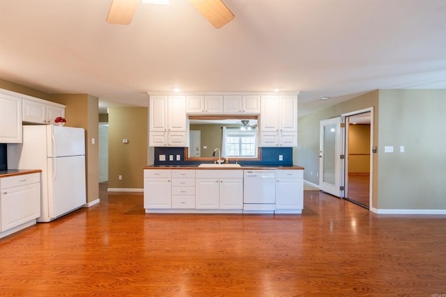 kitchen featuring white cabinets, white appliances, light hardwood / wood-style flooring, and sink