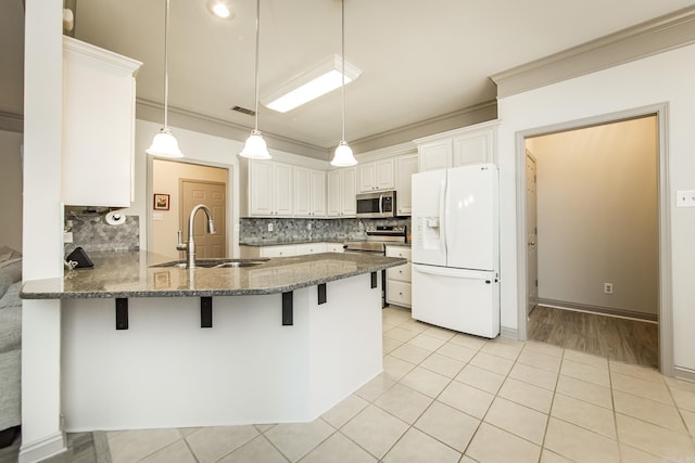 kitchen with sink, stainless steel appliances, decorative light fixtures, white cabinets, and ornamental molding