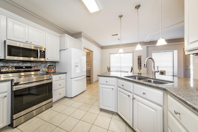 kitchen with sink, white cabinets, stainless steel appliances, and decorative light fixtures