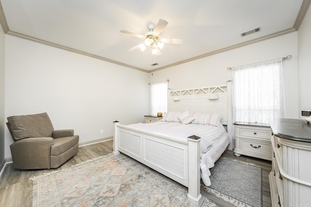 bedroom featuring ceiling fan, light hardwood / wood-style flooring, and ornamental molding