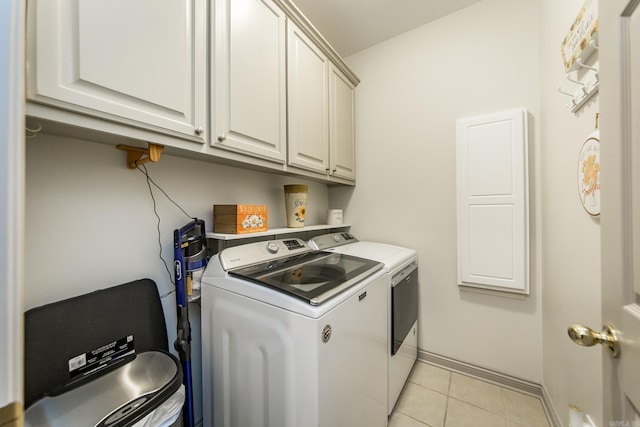 washroom with cabinets, separate washer and dryer, and light tile patterned flooring