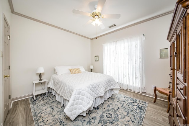 bedroom featuring ceiling fan, light hardwood / wood-style floors, and ornamental molding