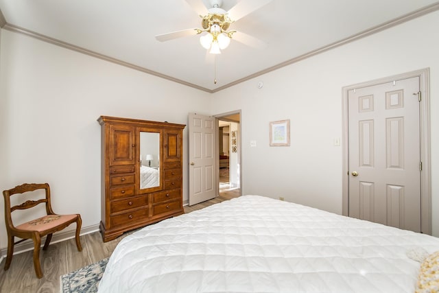 bedroom featuring ceiling fan, crown molding, and light hardwood / wood-style flooring