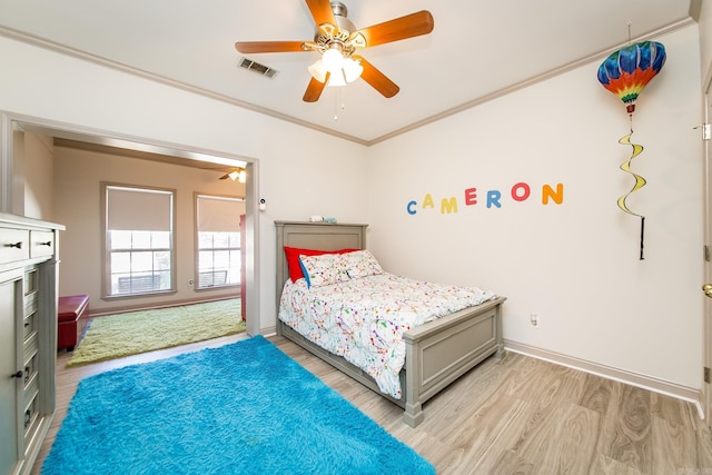 bedroom featuring ceiling fan, crown molding, and light hardwood / wood-style flooring