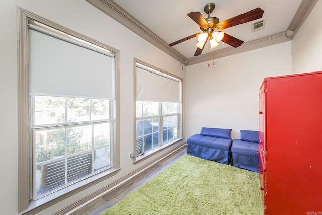 living area featuring hardwood / wood-style floors, ceiling fan, and ornamental molding