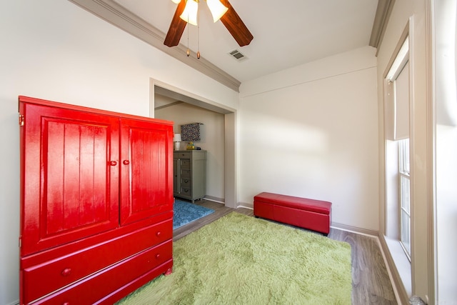 bedroom with dark hardwood / wood-style floors, ceiling fan, and ornamental molding