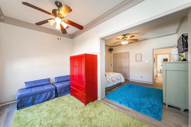 bedroom featuring dark hardwood / wood-style flooring, a closet, ceiling fan, and ornamental molding