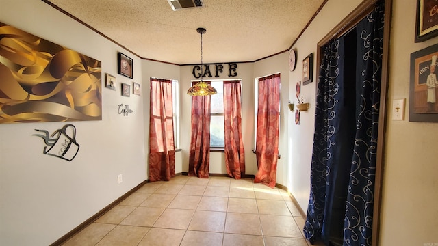 corridor with light tile patterned floors, a textured ceiling, and ornamental molding