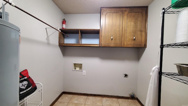 clothes washing area featuring cabinets, hookup for a washing machine, hookup for an electric dryer, a textured ceiling, and light tile patterned floors