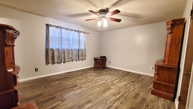 unfurnished bedroom with ceiling fan, dark hardwood / wood-style floors, and a textured ceiling