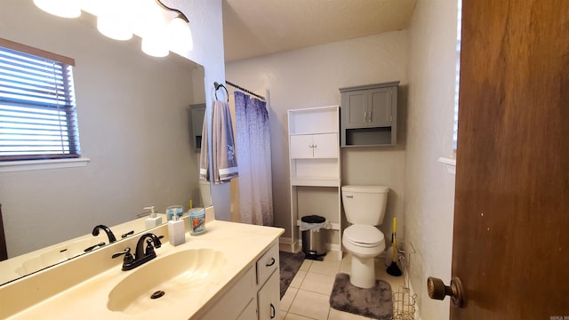 bathroom featuring toilet, vanity, tile patterned floors, and curtained shower