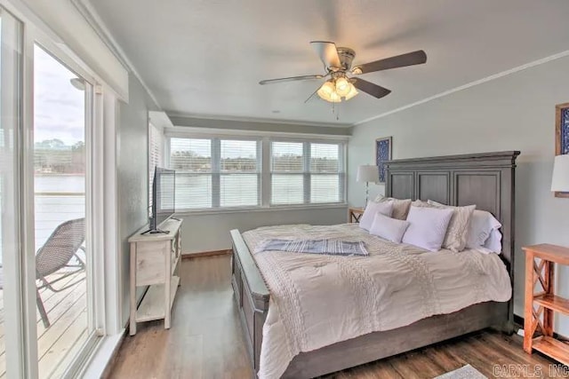 bedroom featuring dark hardwood / wood-style flooring, ceiling fan, and ornamental molding