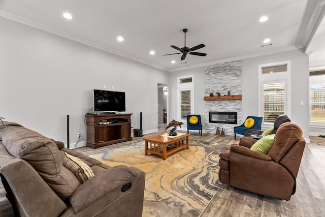 living room with crown molding, a fireplace, ceiling fan, and light hardwood / wood-style flooring