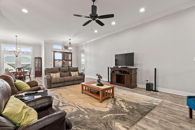 living room featuring french doors, ceiling fan with notable chandelier, light hardwood / wood-style floors, and crown molding