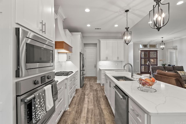 kitchen featuring white cabinets, sink, hanging light fixtures, decorative backsplash, and stainless steel appliances