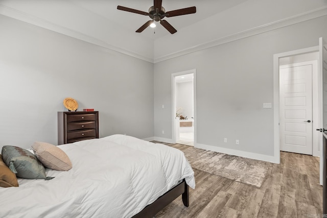 bedroom with ensuite bathroom, crown molding, vaulted ceiling, light hardwood / wood-style flooring, and ceiling fan