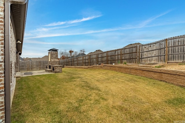 view of yard featuring a patio area and an outdoor fireplace