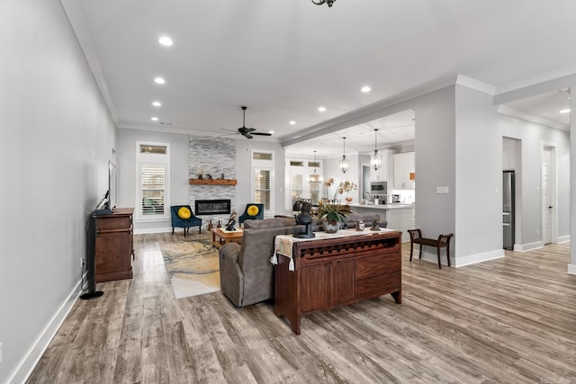 living room featuring a fireplace, light wood-type flooring, and ornamental molding