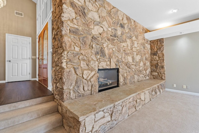 living room featuring carpet flooring and a stone fireplace