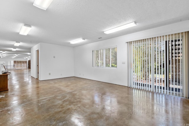 spare room featuring concrete floors and a textured ceiling