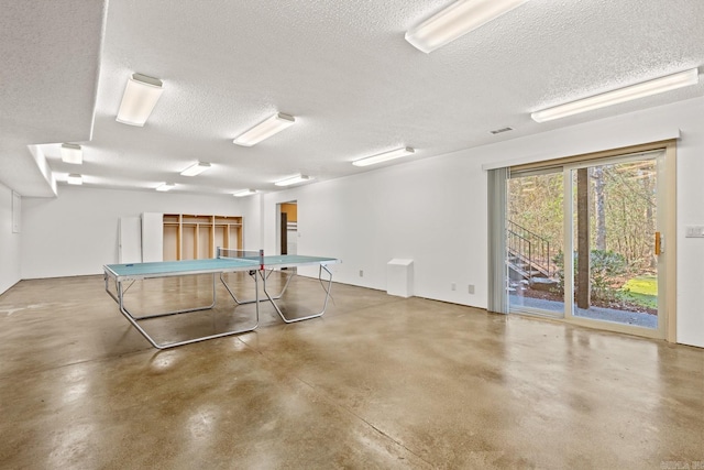 game room with concrete flooring and a textured ceiling