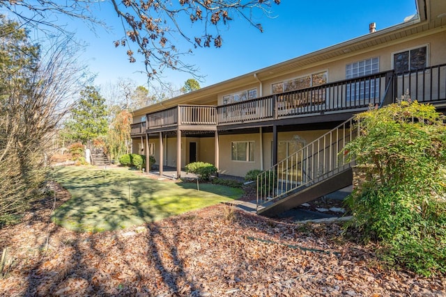 back of property with a lawn and a deck