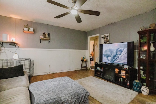 living room with wood-type flooring and ceiling fan