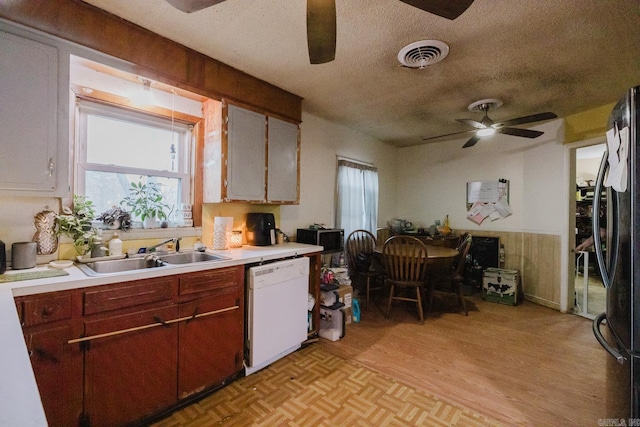 kitchen featuring white dishwasher, refrigerator, sink, light hardwood / wood-style flooring, and a textured ceiling