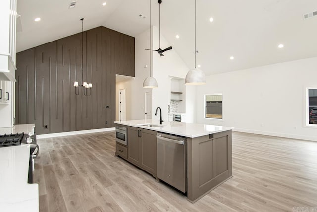 kitchen with gray cabinetry, built in microwave, dishwasher, and sink