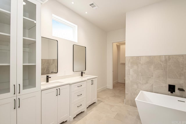 bathroom with a washtub and vanity