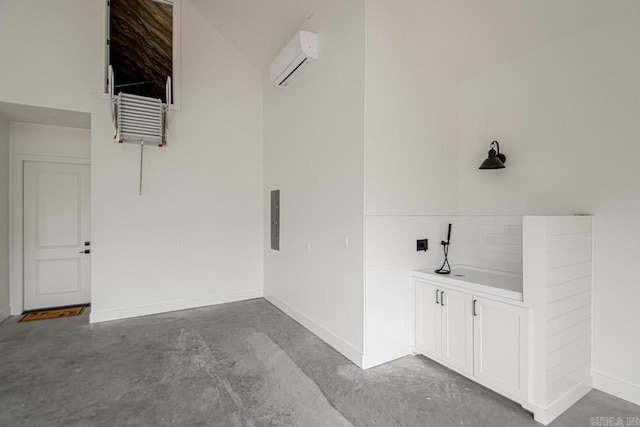 bathroom featuring concrete floors, electric panel, and an AC wall unit