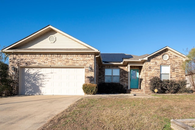 view of front of property featuring solar panels, a garage, and a front yard