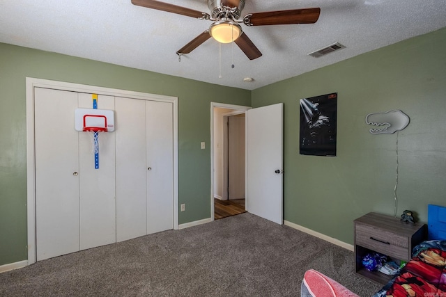 unfurnished bedroom featuring carpet, a textured ceiling, a closet, and ceiling fan